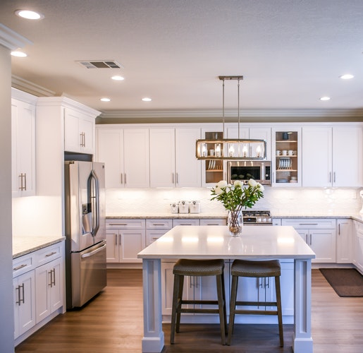 Cocina blanca con isla en una vivienda familiar